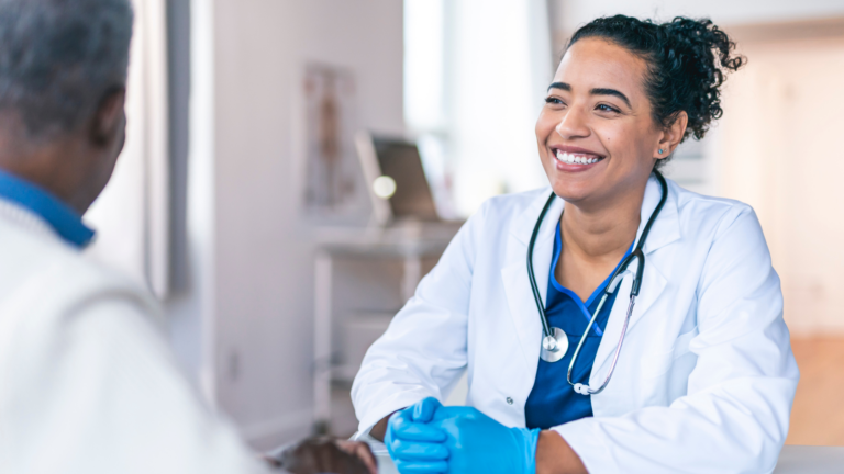 Female locum tenens physician smiles as she discusses her practice with a male colleague