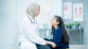 female healthcare worker smiles and enjoys taking care of her young patient