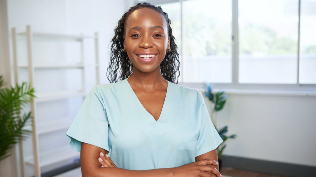 Woman standing arms crossed in nurse attire.